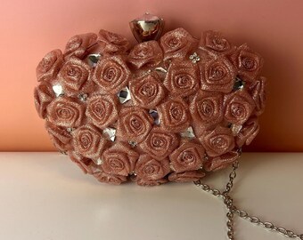 Bolso de mano vintage rosa con forma de concha y estampado floral.