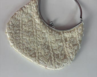 Bolso vintage iridiscente con cuentas y asas plegables plateadas.