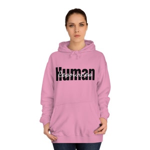 Peut inclure: Sweat-shirt à capuche rose avec le texte "Human Resources" en lettres noires. Le mot "Resources" est écrit en cursive.