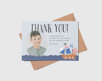 May include: A blue and white thank you card with a photo of a young boy and a cartoon pirate ship. The text on the card reads "Thank You! I enjoyed the cake and the presents too, but my favorite part was celebrating with you! From Jameson."