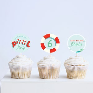 May include: Three cupcakes with different themed toppers. The first cupcake has a red, white, and blue pool party topper with the text "Splish Splash It's a Pool Party". The second cupcake has a red and white life preserver with the number "6" in the center. The third cupcake has a blue and white circle with the text "Happy Birthday Charlie".