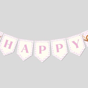 May include: A pink and white polka dot banner with the word "HAPPY" in pink letters. The banner has a pretzel and a green hat on each end.
