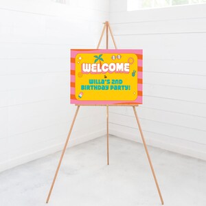 May include: Welcome to Willa's 2nd Birthday Party! A yellow and pink welcome sign with a palm tree, sunglasses, and peace sign graphics.