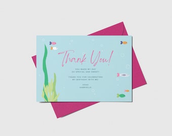 May include: A light blue thank you card with a sea-themed design. The card features a handwritten message that says "Thank You!" and includes the text "You made my day so special and sweet! Thank you for celebrating my birthday with me! xoxo Gabrielle". The card is decorated with colorful fish and seaweed.