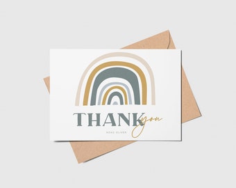 May include: A white thank you card with a rainbow design in shades of beige, blue, and gold. The text "THANK you" is in gray with the words "XOXO OLIVER" in a smaller font below.