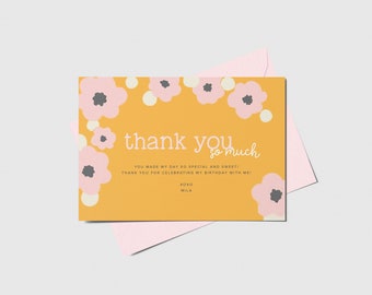 May include: A greeting card with a mustard yellow background and pink floral accents. The text "thank you so much" is displayed in white, along with additional text. A pink envelope is behind the card.