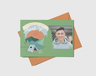 Op de afbeelding: Een groene bedankkaart met een kampeerscène met een tent, bergen en een kampvuur. De tekst "Thank You" is geschreven in witte cursieve letters met de woorden "from Henry" eronder. In de rechterbovenhoek van de kaart staat een foto van een jonge man.