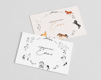 May include: Two white cards with black outlines of horses and floral designs. The text "Happy Birthday Emma" is written in gold cursive on each card.
