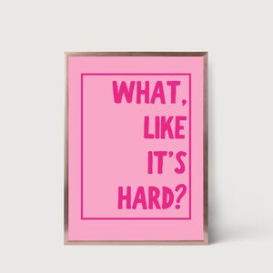 Może przedstawiać: R&oacute;żowy wydruk w ramie z tekstem "WHAT, LIKE IT'S HARD?" w pogrubionych r&oacute;żowych literach.
