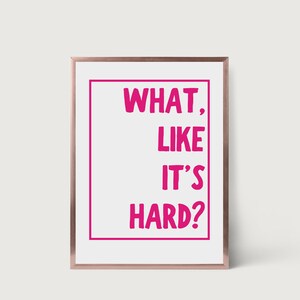 Może przedstawiać: Biały wydruk w ramie z r&oacute;żowym obramowaniem i tekstem "WHAT, LIKE IT'S HARD?" w kolorze r&oacute;żowym.