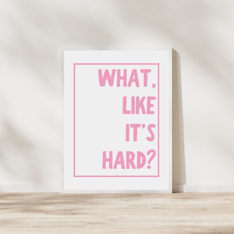 Może przedstawiać: Biała oprawa z nadrukiem w kolorze r&oacute;żowym z tekstem "WHAT, LIKE IT'S HARD?"