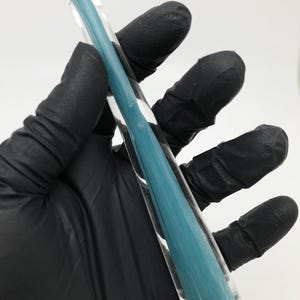 May include: A clear glass tube filled with a teal blue substance. The tube is about 10 inches long and has a rounded end.
