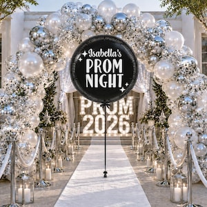 May include: A black round balloon with white text reading "Isabella's PROM NIGHT", set against a backdrop of white and silver balloons. The words "PROM 2026" are illuminated in the background, creating a celebratory scene.