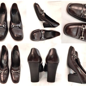 May include: A pair of brown leather heeled shoes with a silver buckle detail. The shoes have a square toe and a chunky heel.