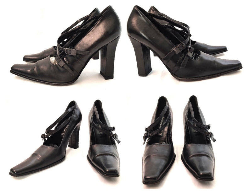 May include: Black leather heeled shoes with a pointed toe and multiple straps across the foot. The shoes have a chunky heel and a buckle detail.