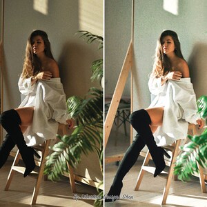 May include: A woman wearing a white shirt and black thigh-high boots sits on a wooden stool in front of a green plant. The background is a light beige wall with a shadow cast from a window.
