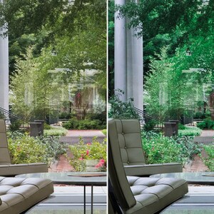 May include: Two light brown leather chairs with a glass table in front of them. The chairs are facing a large window with a view of a lush green garden with trees and bushes.