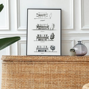 May include: Black and white line drawing of a house with four different floor plans. The drawing is framed and hanging on a white wall above a woven wicker chest.