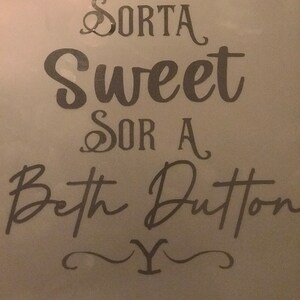 May include: A gray background with black text that reads "Sorta Sweet Sor A Beth Dutton Y".