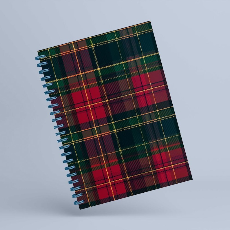 May include: A spiral-bound notebook featuring a classic plaid pattern in red, green, yellow, and brown. The notebook has a blue spiral binding and a hard cover. The plaid design is a traditional tartan pattern.
