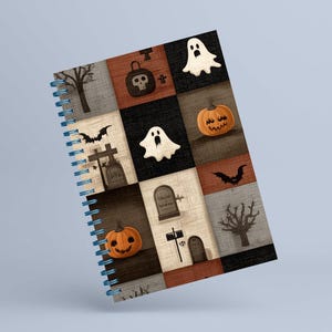 May include: A spiral-bound notebook with a Halloween design. The cover has a patchwork pattern with spooky illustrations, including pumpkins, ghosts, bats, and tombstones. The colour palette includes orange, black, and grey.