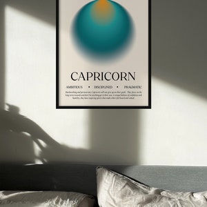 May include: Capricorn zodiac art print in a black frame. The poster features a teal and orange gradient sphere, the word "CAPRICORN", and the dates "DEC. 22 - JAN. 20". The print also lists the traits: ambitious, disciplined, and pragmatic.