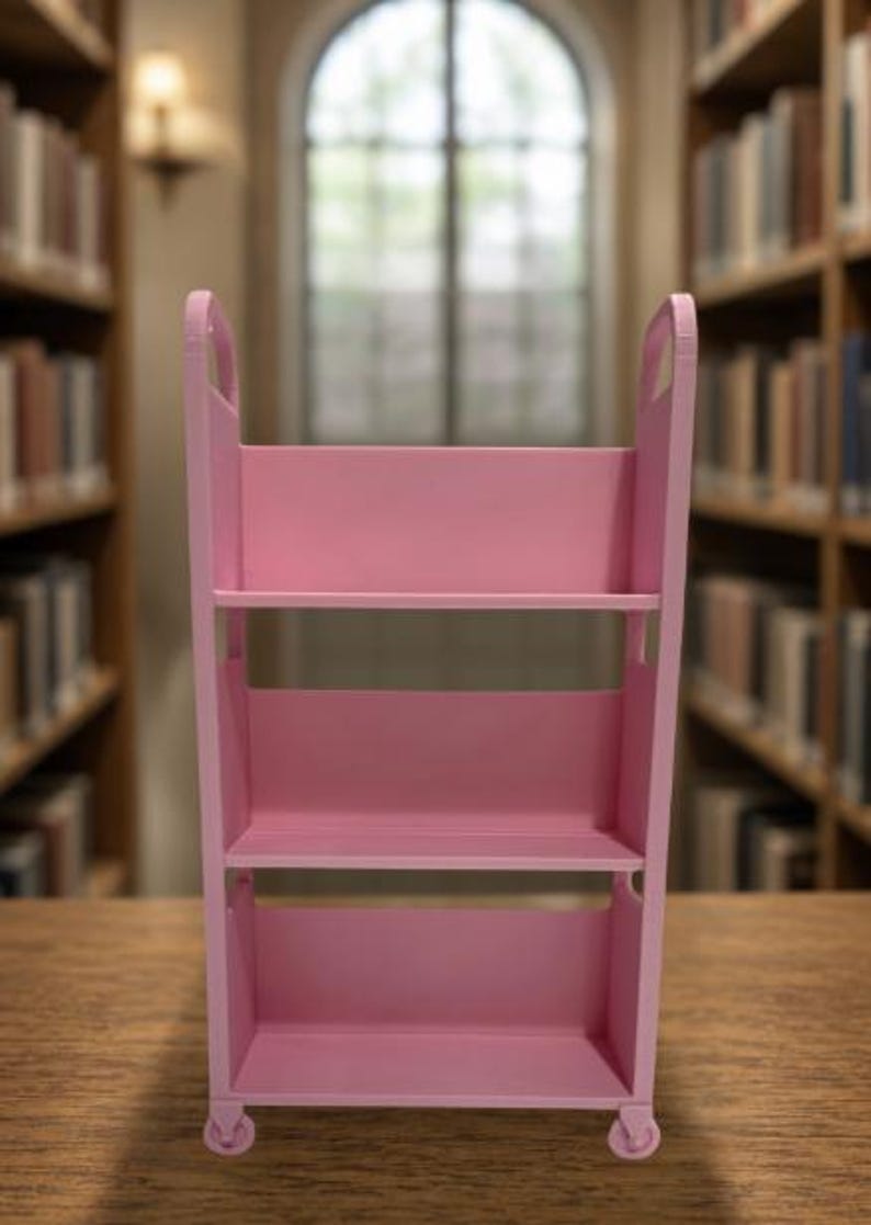 May include: A pink three-tiered rolling utility cart with open shelves and side handles. The cart features a rectangular frame with four small wheels at the base, providing a storage solution with three distinct levels for organizing various items.