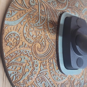 Extreme close-up of the laser-engraved wood grain, highlighting the detailed paisley swirls and the vintage turquoise paint wash in the recessed areas.