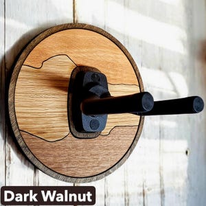 Handcrafted dark walnut guitar wall hanger with round wood base and adjustable padded instrument support arms