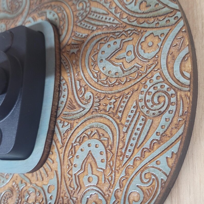 Extreme close-up of the laser-engraved wood grain, highlighting the detailed paisley swirls and the vintage turquoise paint wash in the recessed areas.