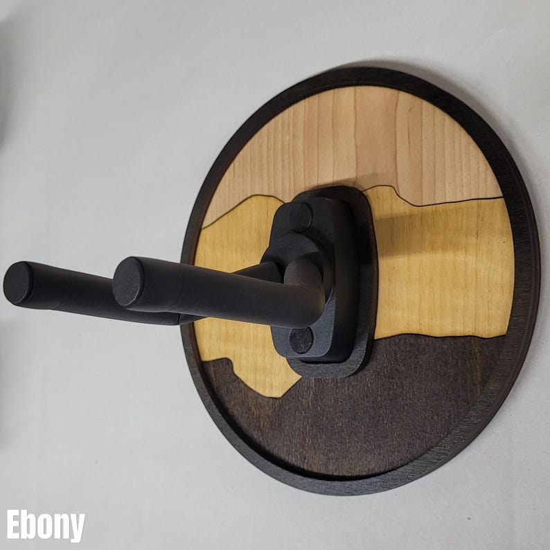 Ebony and maple layered wood guitar hanger wall mount with round backplate and black foam covered steel support arms