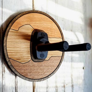 Handcrafted dark walnut guitar wall hanger with round wood base and adjustable padded instrument support arms