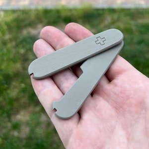 May include: Two gray plastic multi-tools with a cross symbol on one of the tools.