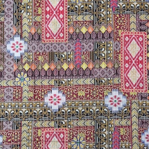 Può includere: Primo piano di un tessuto con un design patchwork. Il motivo presenta forme geometriche, motivi floreali e motivi a diamante in rosso, oro, nero e bianco. Il tessuto ha un aspetto strutturato.