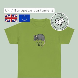 Könnte beinhalten: Ein grünes T-Shirt mit einer schwarzen Rattenillustration und dem Wort "rat" auf der Vorderseite. Das T-Shirt hat einen Rundhalsausschnitt und kurze Ärmel. Das T-Shirt ist von The Artful Possum.