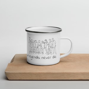 May include: White enamel mug with a black line drawing of a group of people and the text "but legends never die".