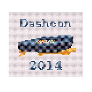 Pode incluir: Um padrão de ponto cruz com uma imagem azul e amarela de um console de videogame e o texto "Dasheon 2014".