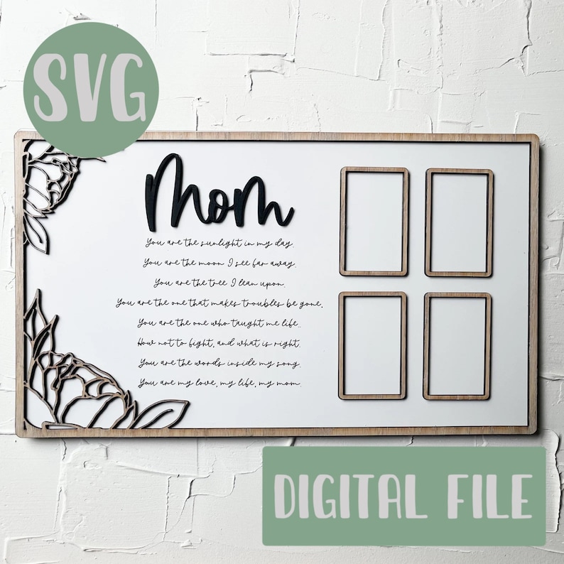 Op de afbeelding: Een wit houten bord met een zwarte inscriptie die "Moeder" luidt en een gedicht over moederschap. Het bord heeft vier rechthoekige uitsparingen voor foto's. Het bord is omgeven door een decoratieve bloemvormige rand.