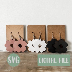 Puede incluir: Tres pares de pendientes con forma de flor. Los pendientes están hechos de madera y vienen en rosa, blanco y negro.