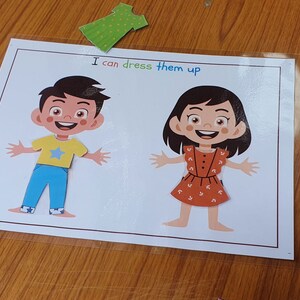 May include: A printable activity sheet with two cartoon figures, a boy and a girl, with the text "I can dress them up".