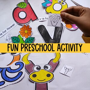 May include: A fun preschool activity with colorful cut-out letters and pictures. The letters are V, A, and F. The pictures include a flower, a butterfly, a bull, and grapes. The text "V is for flower" is visible on a white card.