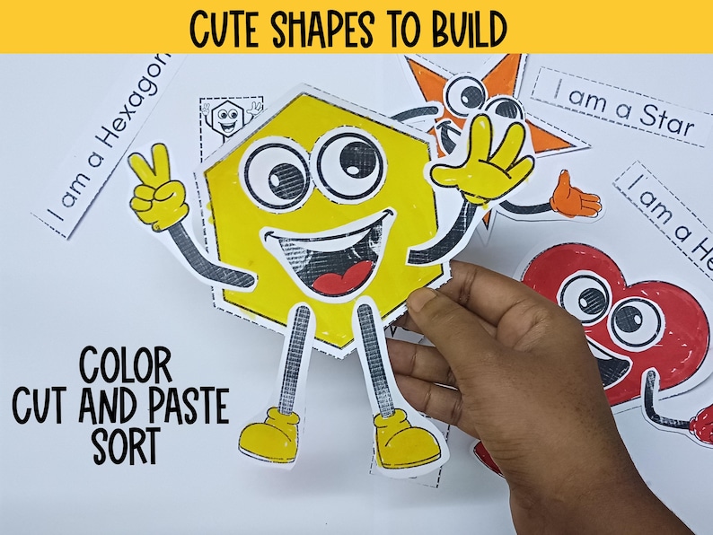 May include: A set of colorful cut-out shapes with faces, including a yellow hexagon, a red heart, and an orange star. The text "I am a Hexagon", "I am a Star", and "I am a Heart" are written on separate white cards. The text "COLOR CUT AND PASTE SORT" is written in black on a white background. The text "CUTE SHAPES TO BUILD" is written in black on a yellow background.
