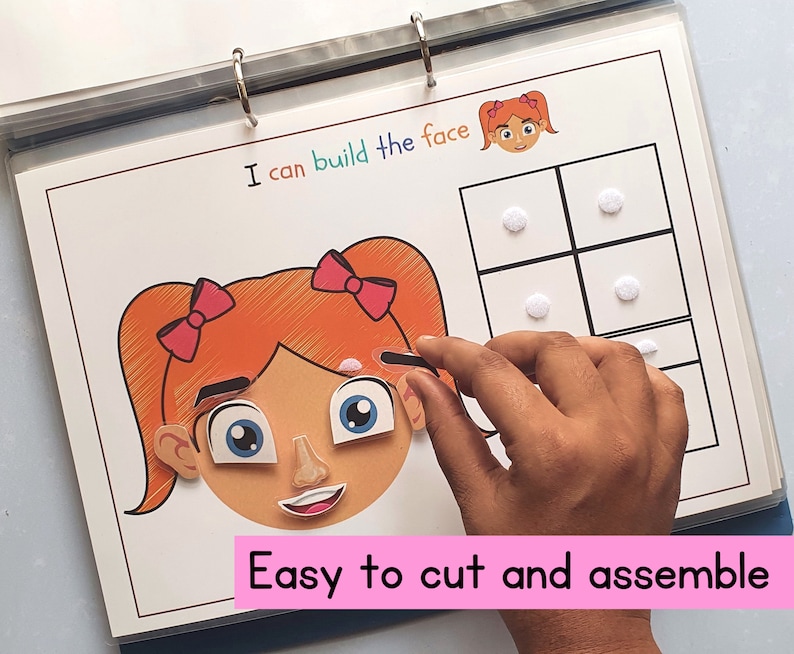 May include: A colorful felt activity book with the text "I can build the face" and a girl's face with cut-out features. The book includes a grid with felt pieces to complete the face. The text "Easy to cut and assemble" is at the bottom of the page.