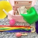 9 piece Sensory box for babies | Baby sensory set UK | Baby sensory Rainbow ribbon ring Spiky Ball Maracas Silver Blanket Sensory Scarf 