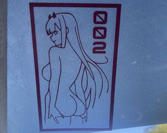 May include: A black and white line drawing of an anime character with long hair and a headband. The character is standing with their back to the viewer. The drawing is on a white background with the word "002" in black text to the right of the character.