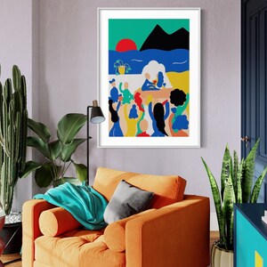 May include: A framed wall art print featuring a vibrant, flat-style illustration of a group of people gathered on a terrace overlooking a blue sea, a red sun, and black mountains. The scene includes a yellow potted plant and figures in colorful clothing.