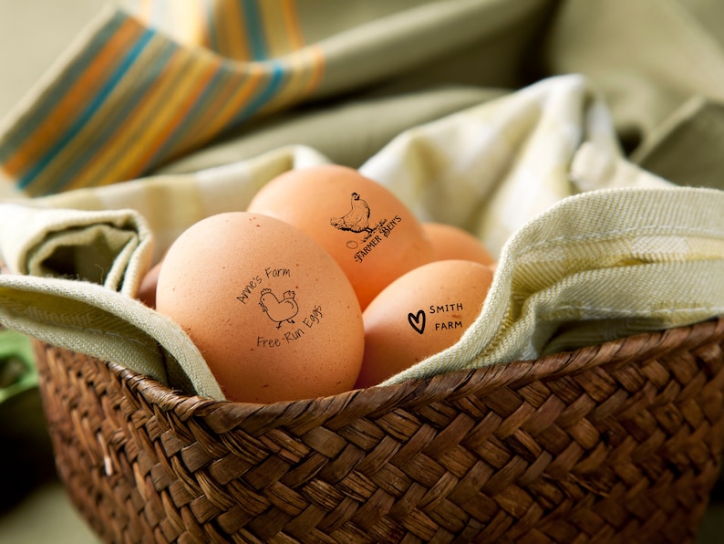 May include: A wicker basket filled with brown eggs. The eggs are stamped with different farm names and logos, including "Barnes' Farm Free Run Eggs", "Smith Farm", and "Harper & Bet's".