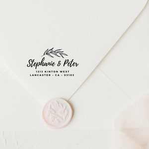May include: A white envelope with a black return address stamp that reads "Stephanie & Peter 1313 Kinton West Lancaster, CA 03103". The stamp features a simple floral design. A pink wax seal with a floral design is on the envelope.