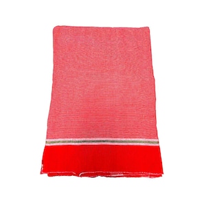 May include: A folded red textile with horizontal stripes. The fabric has a solid red border at the bottom, with a thin band of gold and white stripes above it. The textile is likely a scarf or shawl.