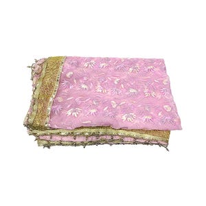 May include: A pink sheer fabric with embroidered floral patterns. The edges are trimmed with gold and silver embellishments. The fabric is folded and appears to be a scarf or shawl.